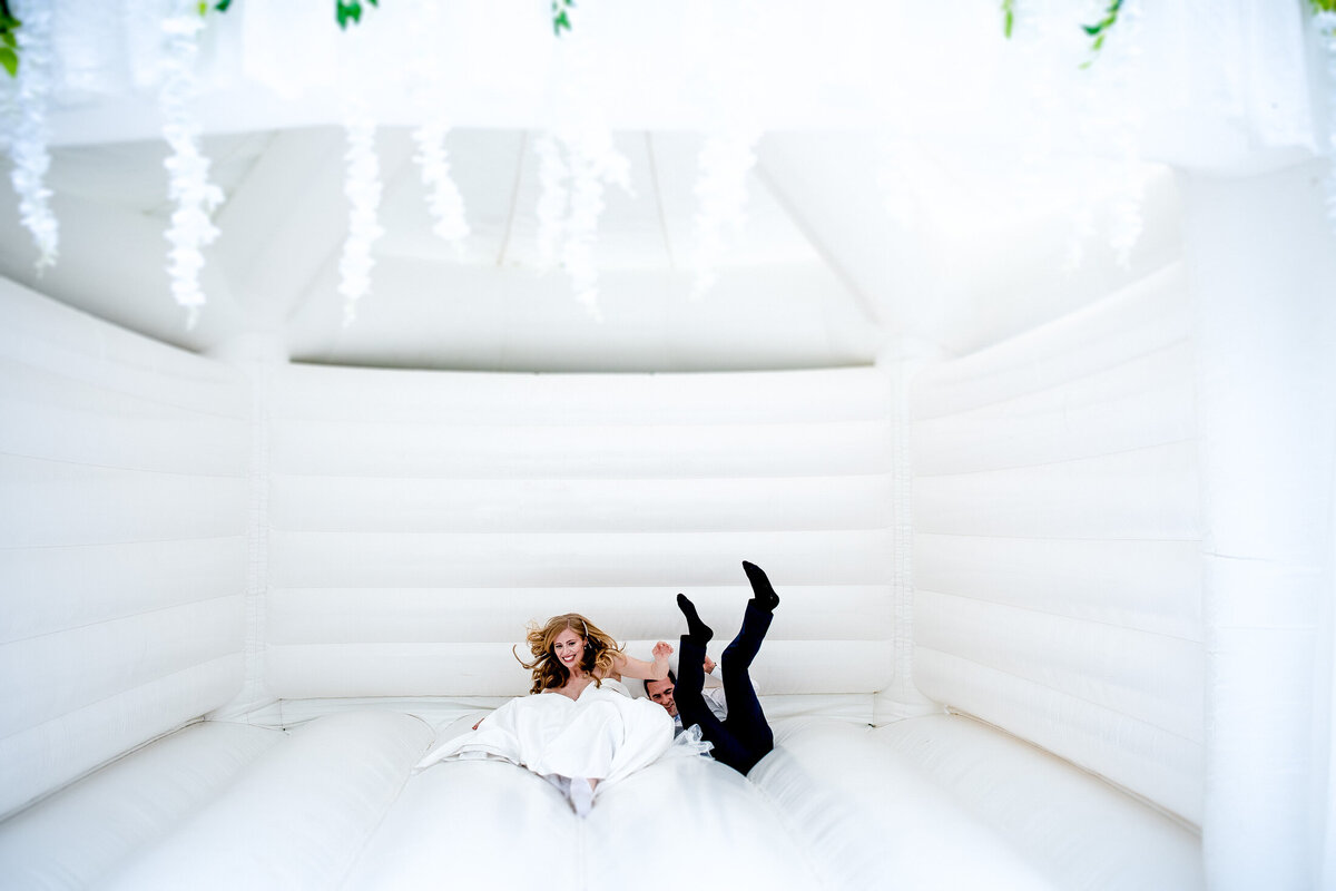 bride and groom on bouncy castle jumping up and down