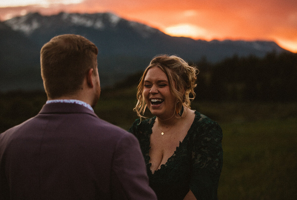 couple laughs during first dance in colorado mountains