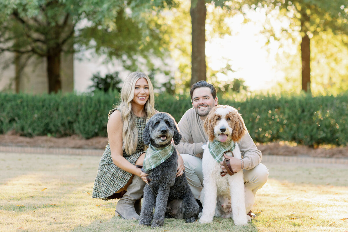 Couple smiling with their two dogs in a park