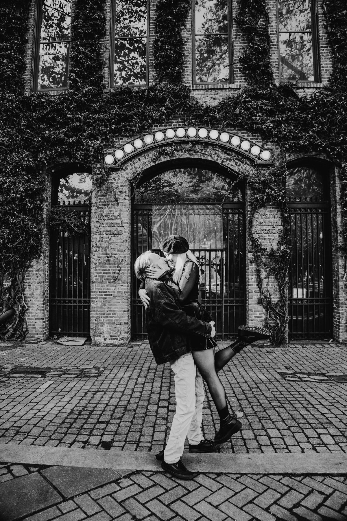 a couple in front of a well known Seattle, Pioneer Square photo spot. husband is picking up his wife.