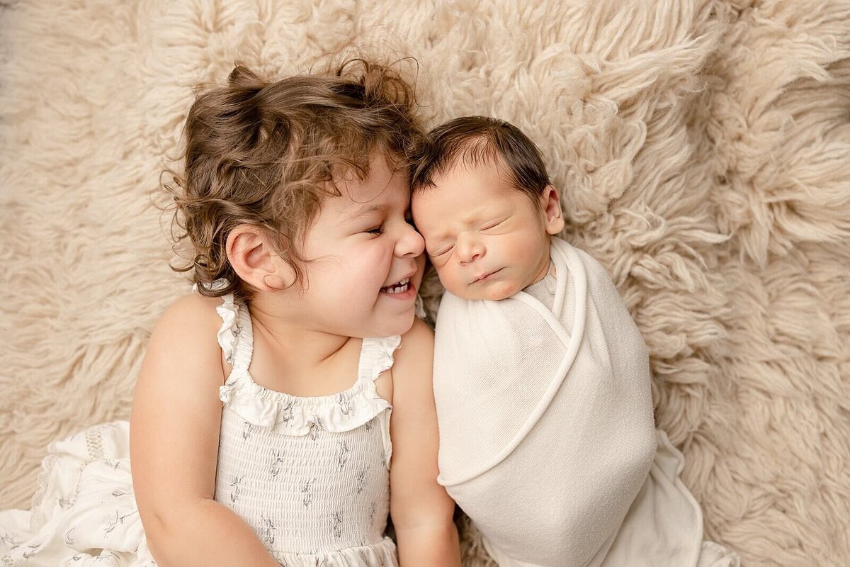 big sister smiling at baby brother