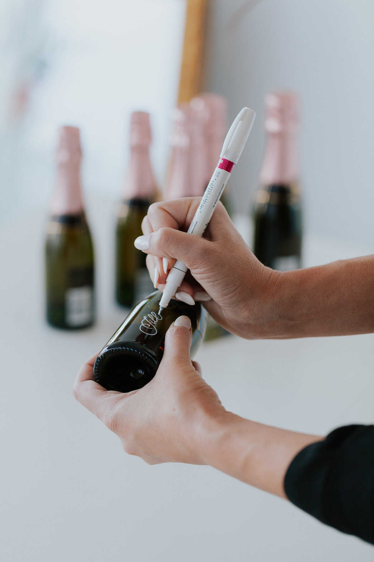detail-photo-calligrapher-writing-on-champagne-photo-with-white-sharpie-for-brand-session-the-frame-charlotte