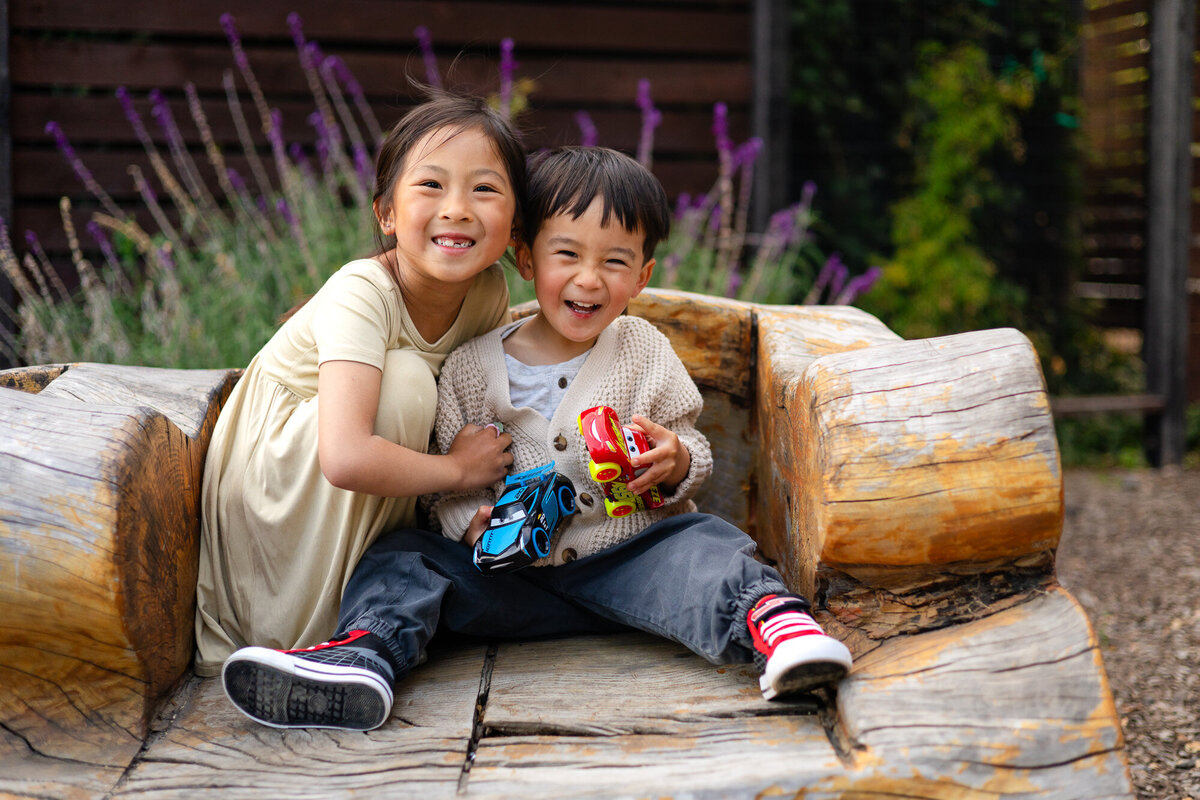 Joyful siblings laughing on a wooden bench – Bay Area Family Portfolio - Ellobelle Photography Family Photographer