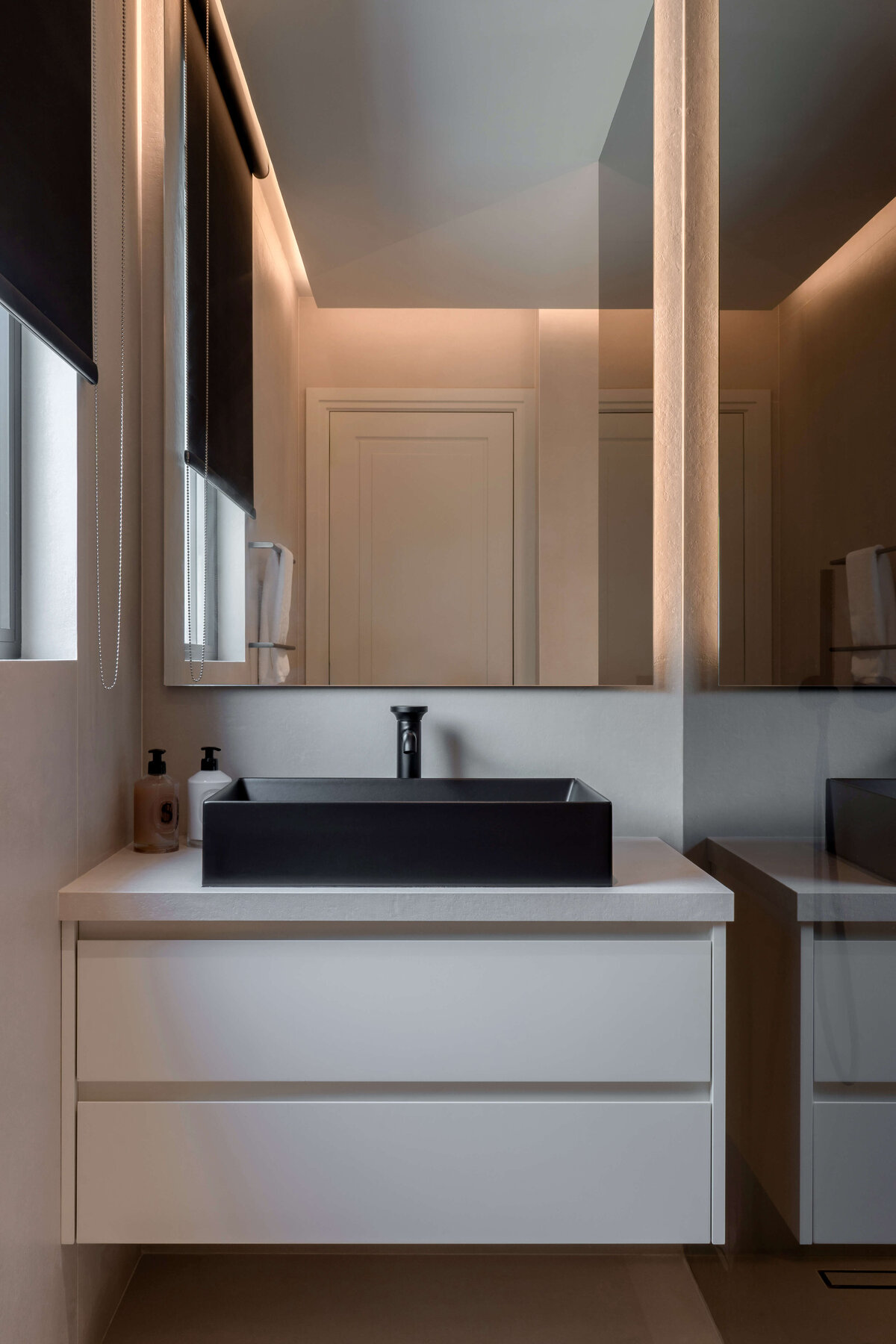 Sleek, modern black sink in a white counter in a modern guest bathroom.