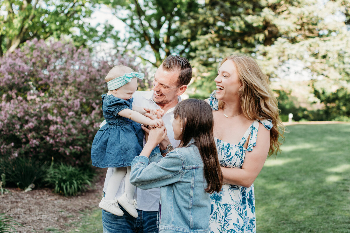 all attention on the baby sister during a family photoshoot in Lilacia Park, Lombard, IL