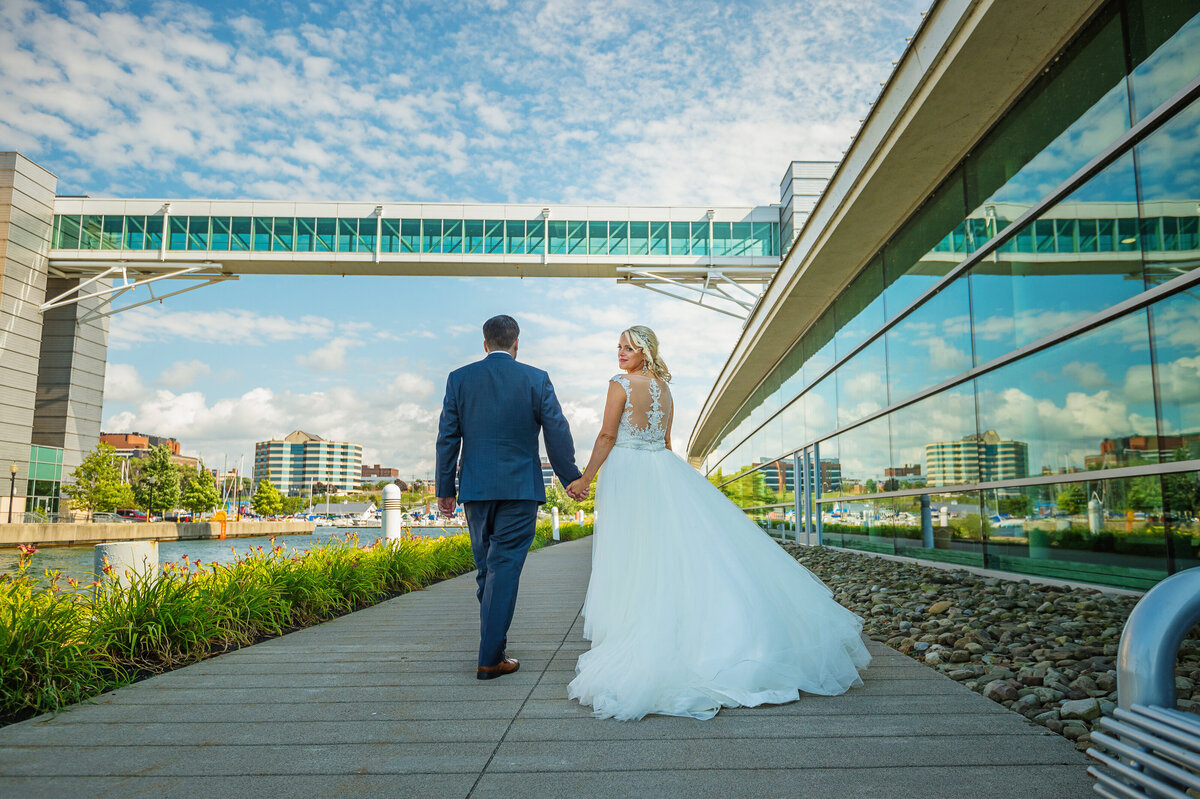 Wedding couple walking on Erie Bayfront by Erie Convention Center.