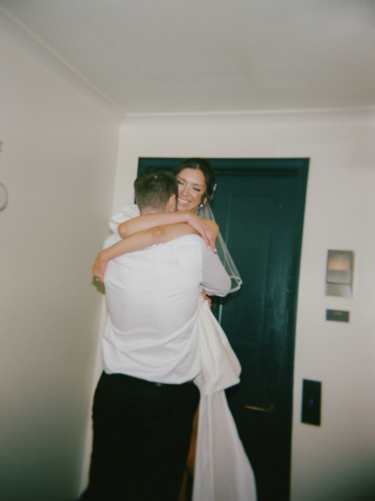 groom lifts bride in short wedding reception dress, Shinola Hotel