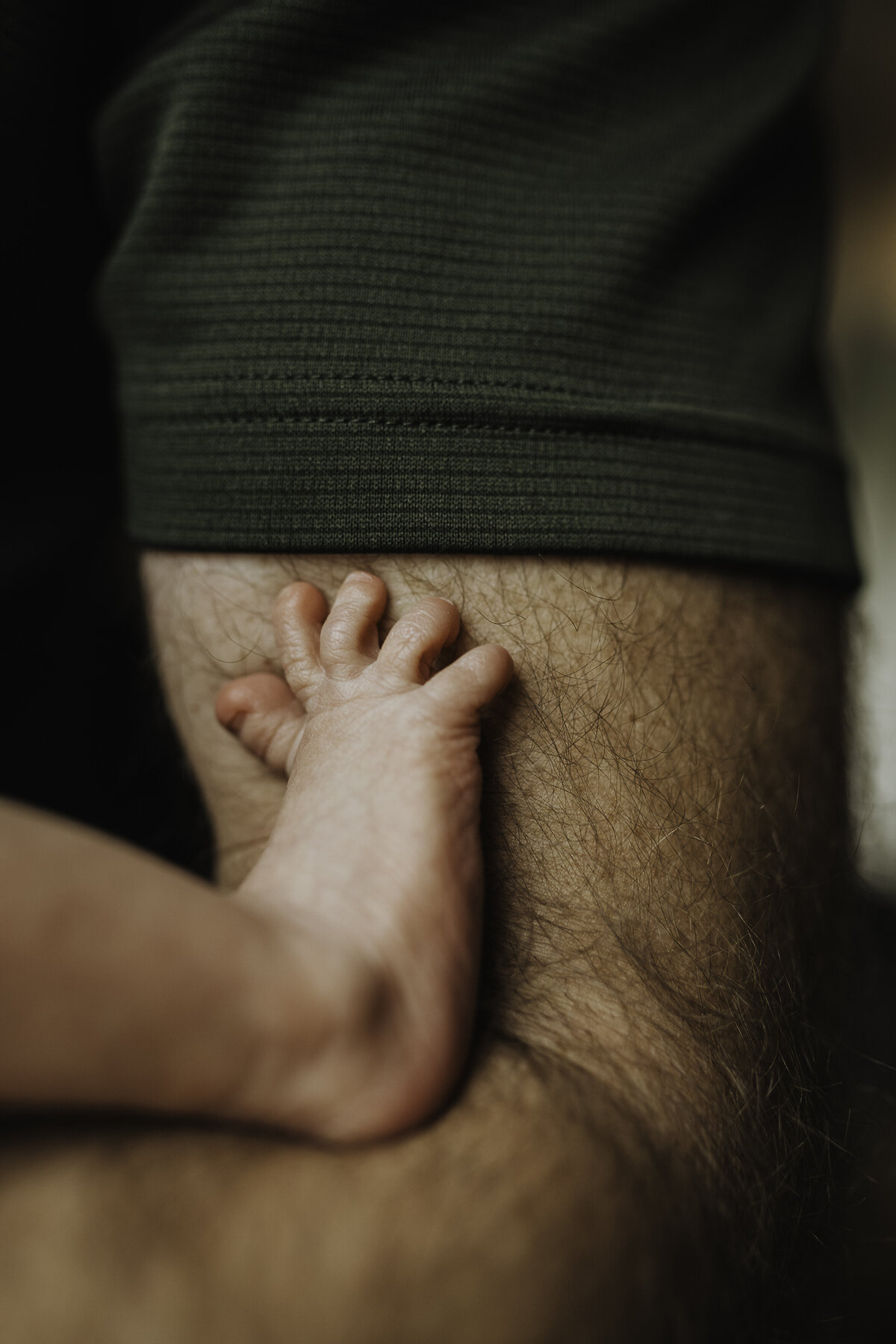 Verona B Photography captures baby details of a newborn – a baby’s foot pressed up against his daddy’s arm at an in-home newborn session near Akron, Ohio. Absolutely nothing as cute as baby feet!