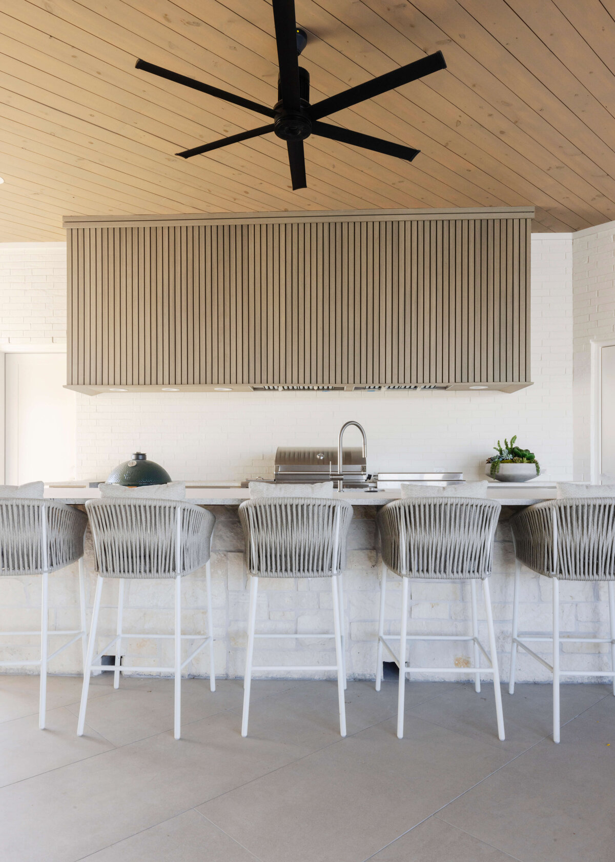 oyster creek studios hughes white stools in bar area with black fan