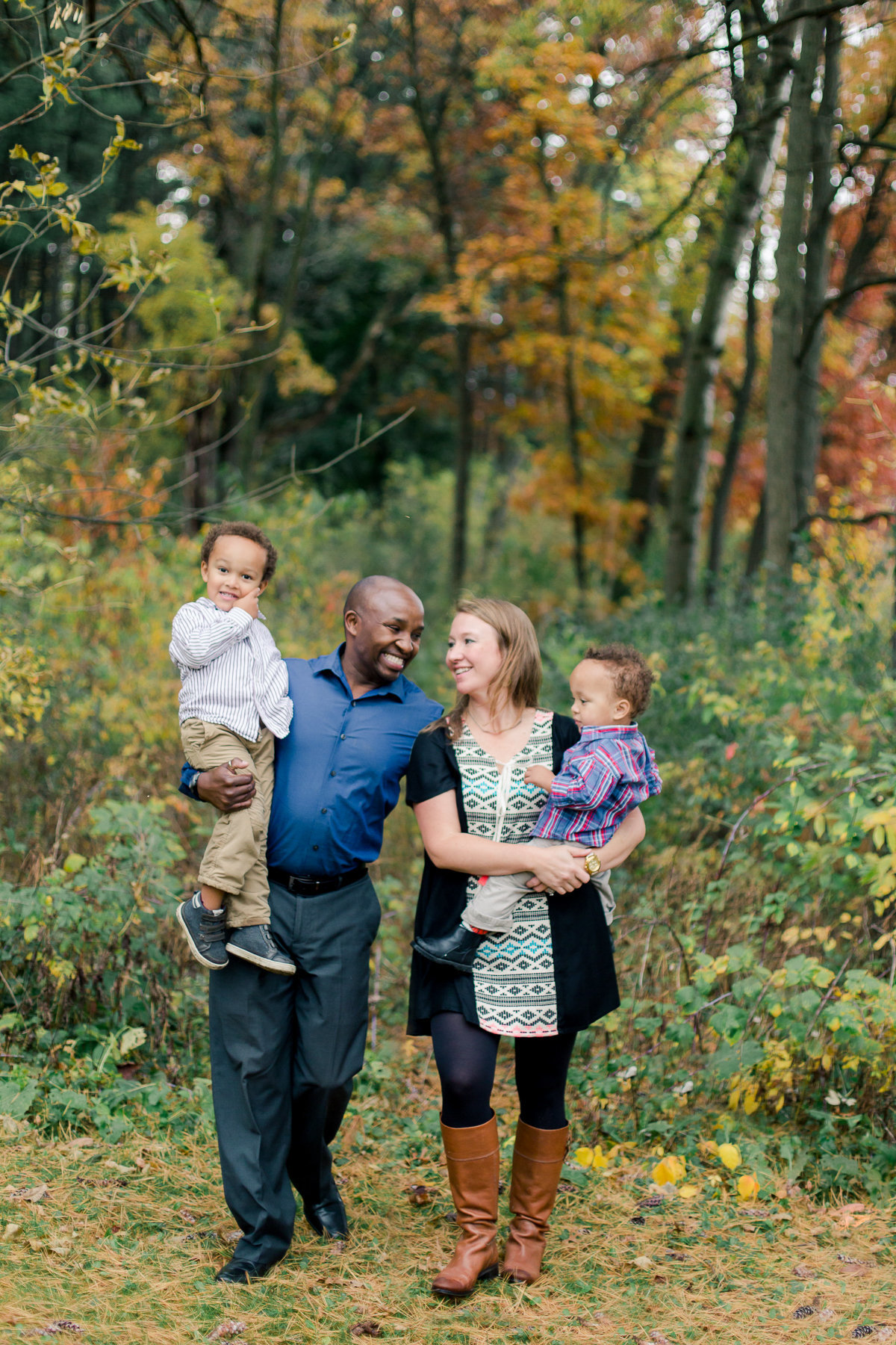 family walks along colored trees at quarry hill park in rochester minnesota family film photography