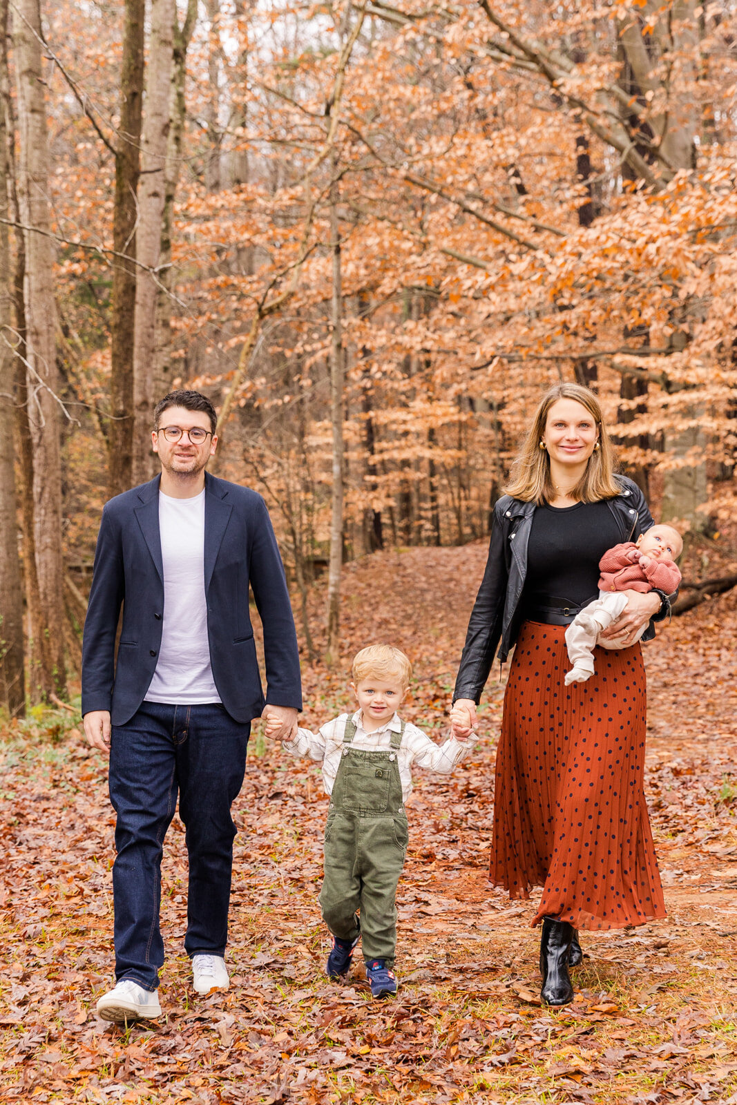 family with a toddler and a baby walking in the woods during their family photo session  | Atlanta GA family Photographer | Laure Photography