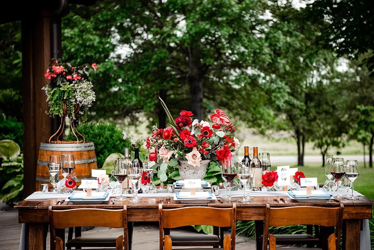Farm table set with large floral centerpiece with red and pink  flowers at Arrington Vineyards