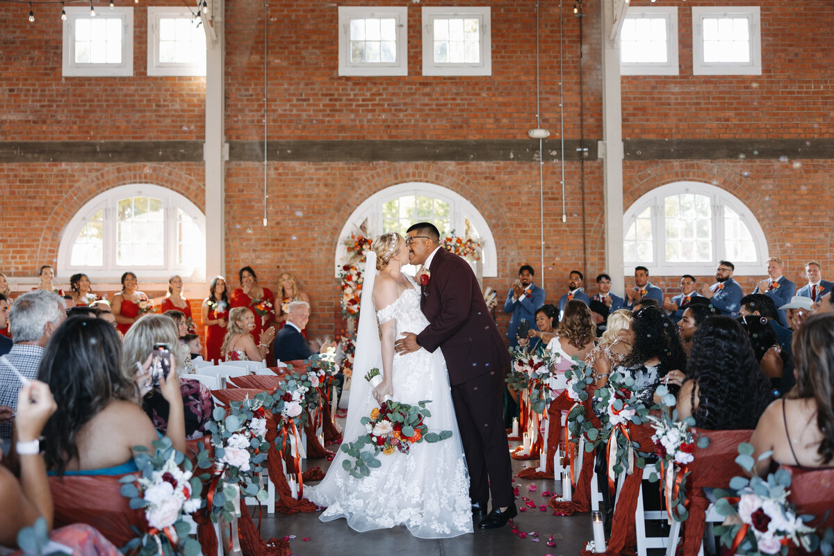 brick wedding, liberty station wedding, bride and groom walking down the aisle, wedding ceremony, bride and groom kissing