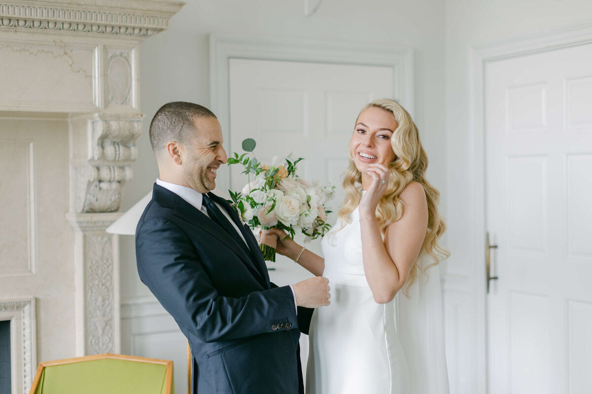 A bride and groom laugh with one another.
