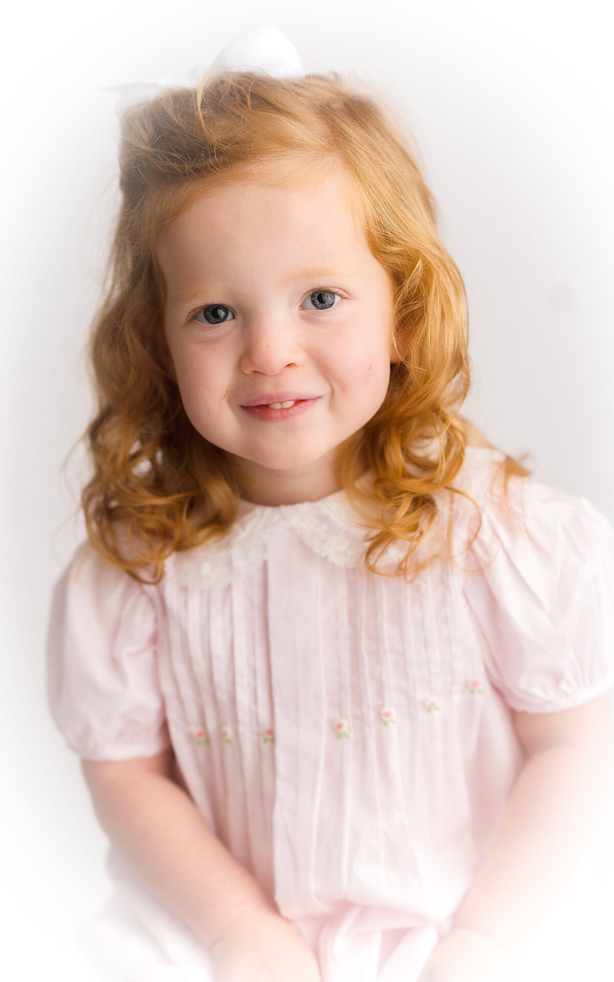 Little girl smiles at the camera during her Heirloom Portrait Photoshoot in Charleston.