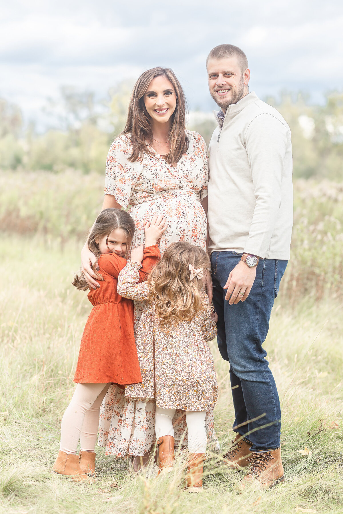 Family snuggles up to Mommas belly for maternity session taken by Plymouth Michigan Newborn Photographer