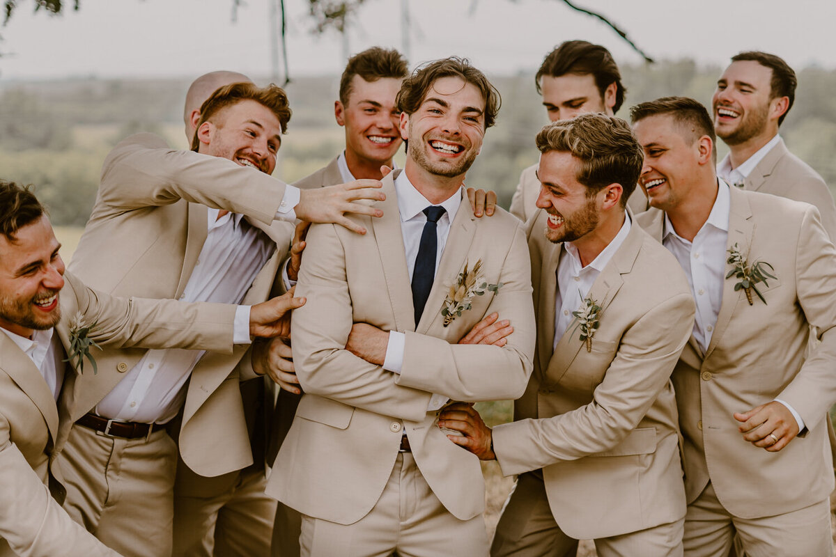 groom-and-groomsmen-portrait-laughing-iowa-des-moines-wedding-photographer-storyteller-collective-photo-co
