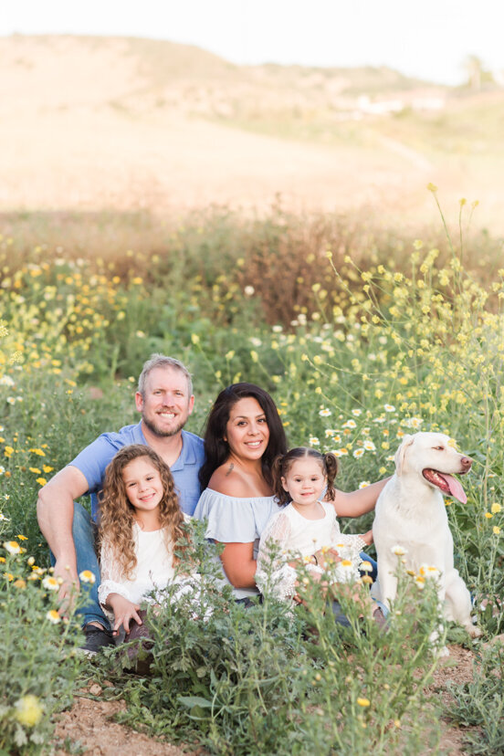 family-sitting-in-daisy-field-Bonita-San-Diego