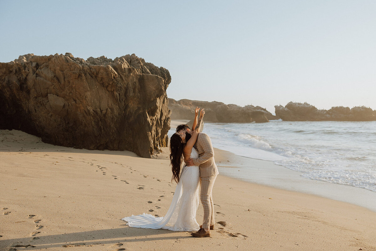 bride and groom embracing on a beach