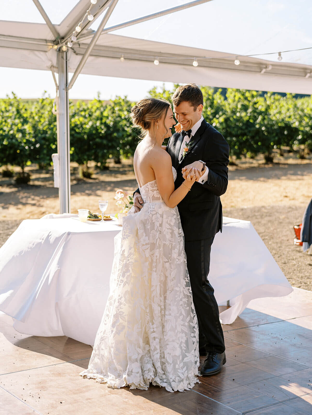 A bride and groom dancing at their outdoor wedding reception.