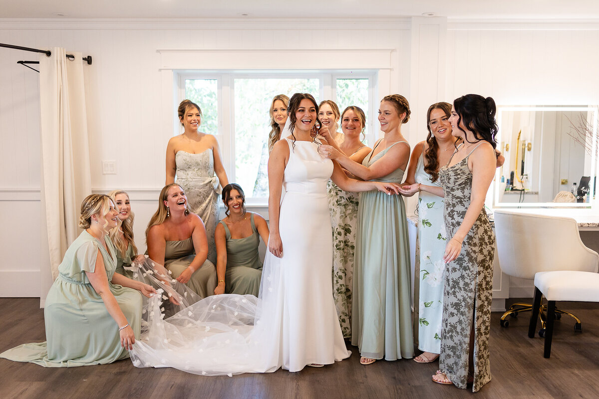 bridal party fluffing and putting the finishing touches on brides and her gown