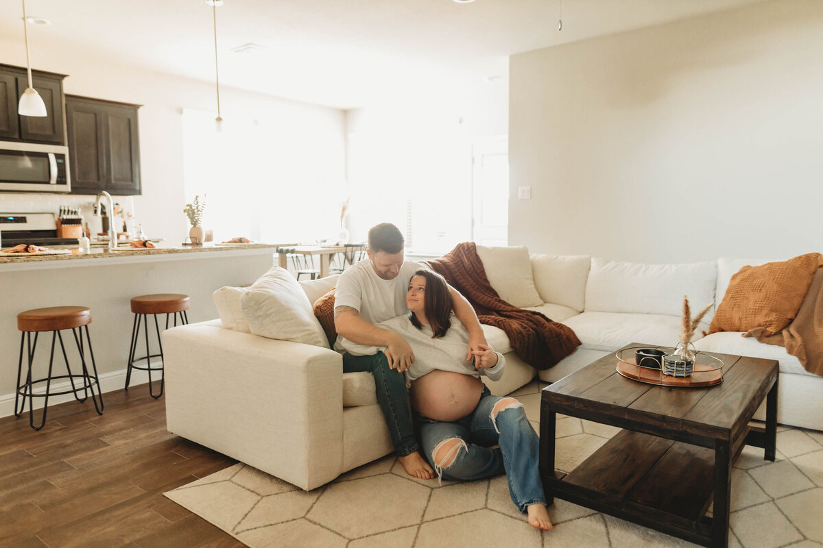 pregnant couple snuggling up in their living room