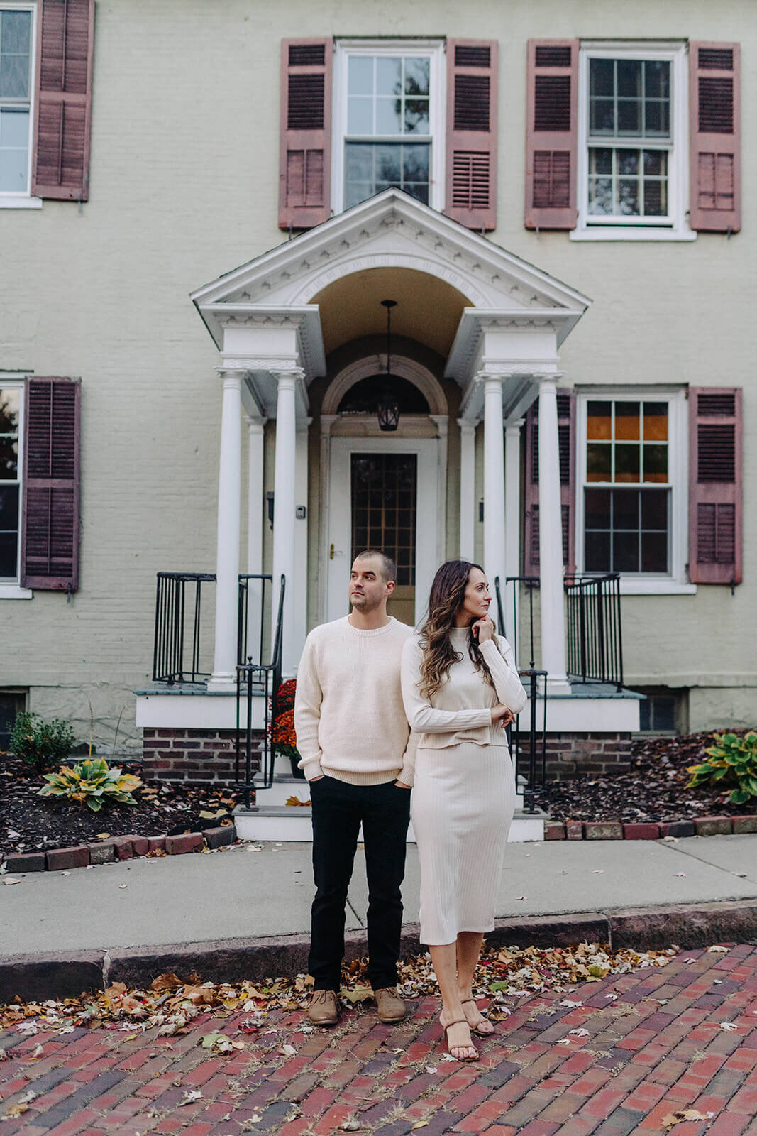 Couple looking in opposite directions outside a house in Finger Lakes NY
