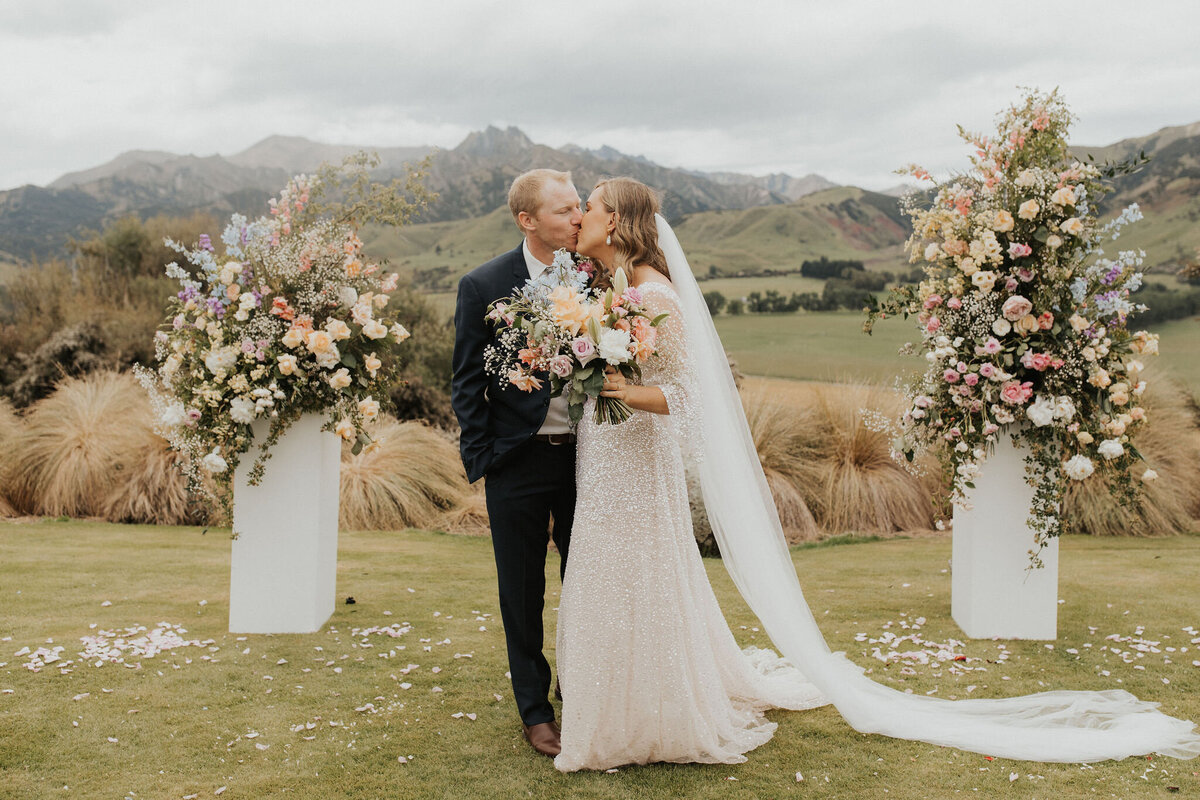 The Vase Floral Co - bride and groom with large standing floral arrnagements and bouquet