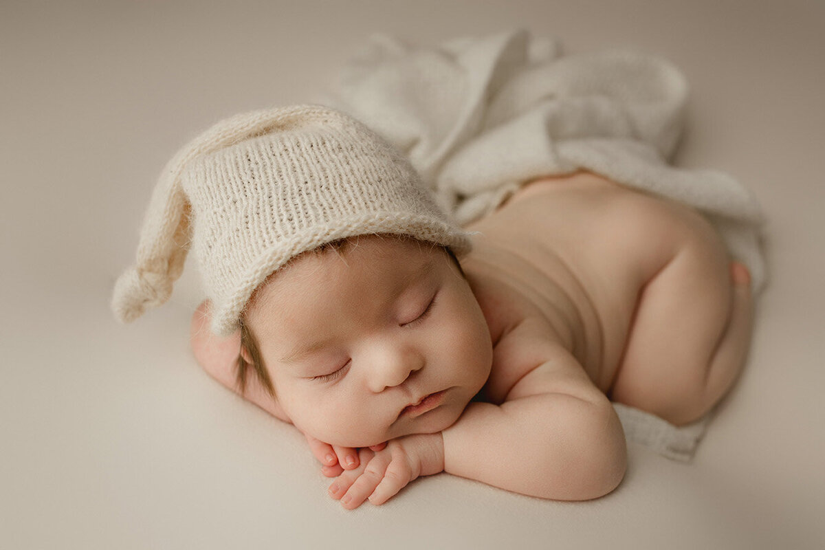 baby boy sleeping facing forward with chin on hands