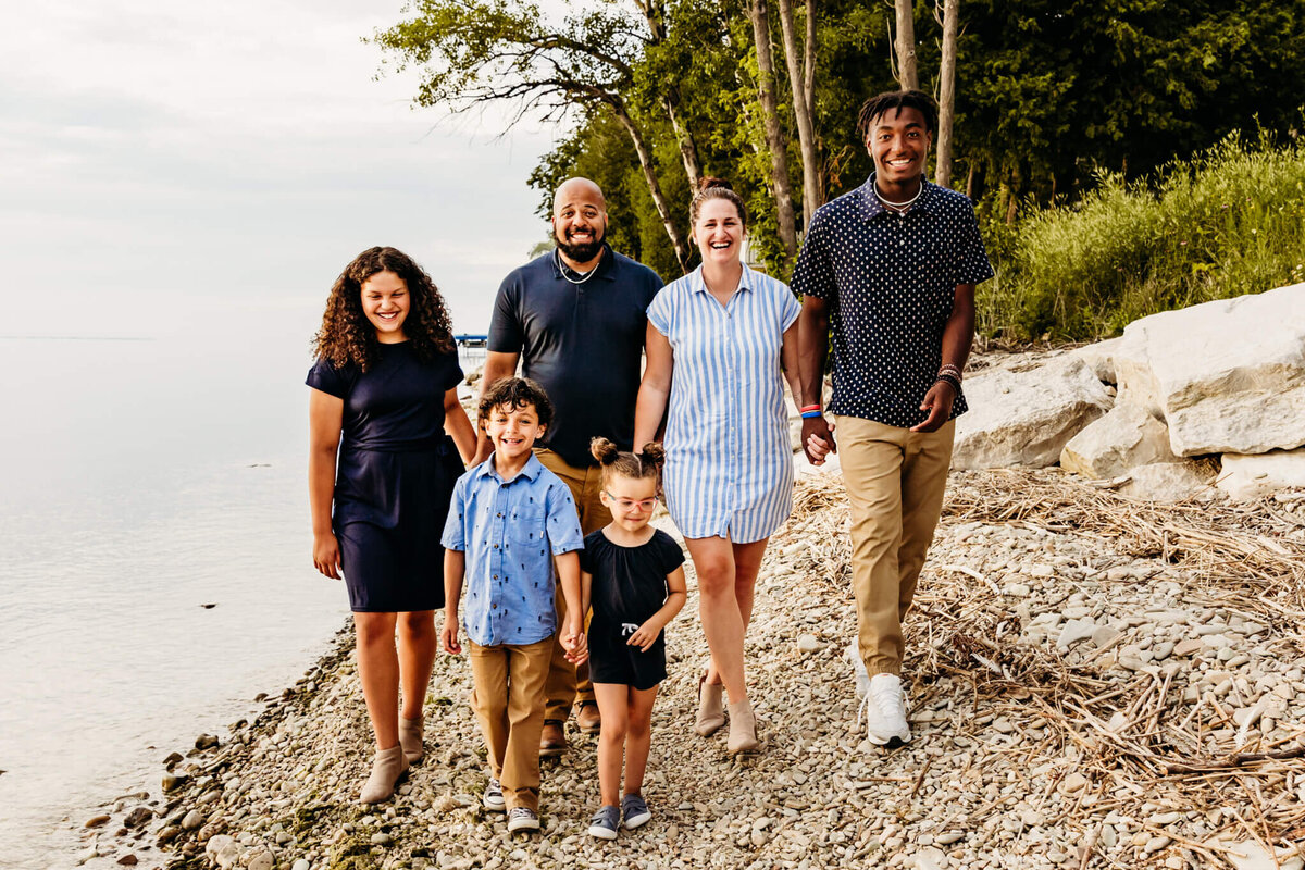 Family of 6 walking along the shore in Sturgeon Bay during their photo session.