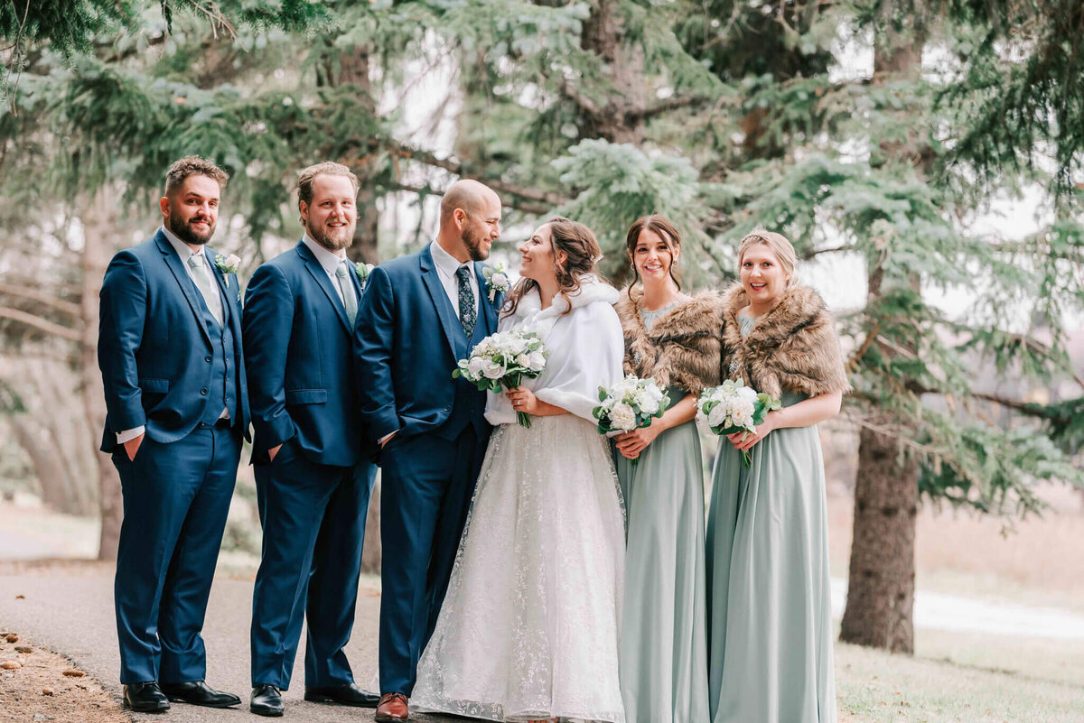 Bride and groom stand on a path with their bridal party.