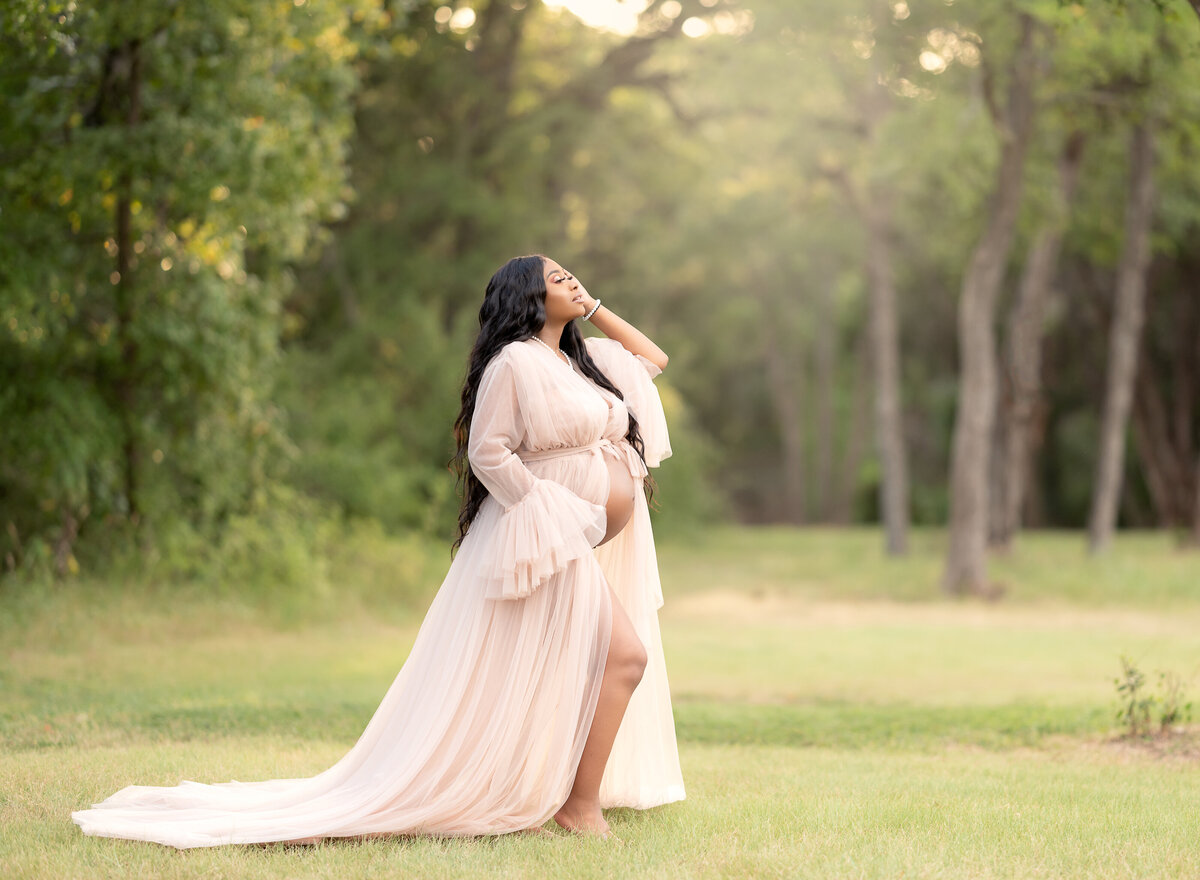 pregnant woman wearing soft peach tulle gown for maternity photos at Brushy Creek Sports Park