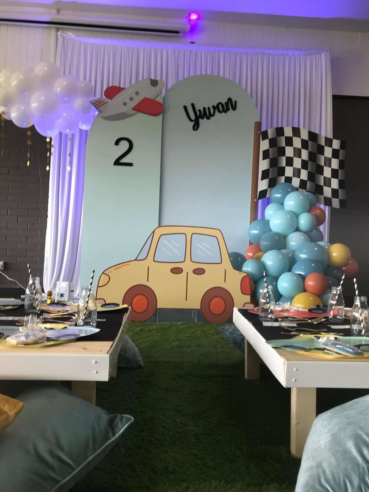 Kid's race car party set up with car backdrop and balloons