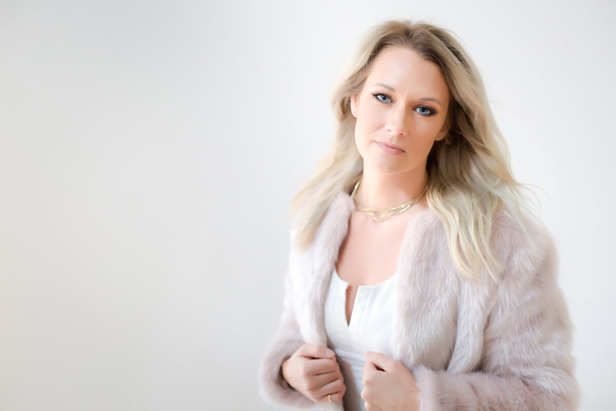 Woman headshot client wearing a fluffy pink jacket