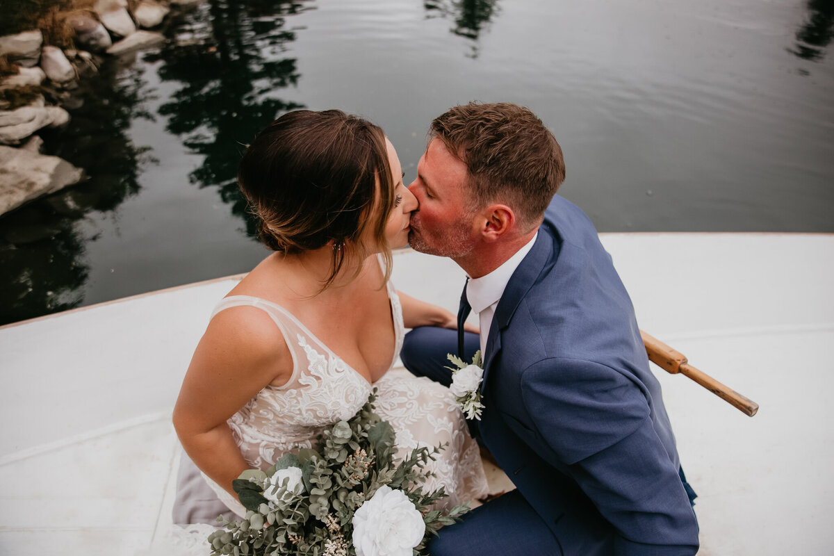 Couple kissing in a boat on the water captured by Nikki Collette Photography, adventurous and romantic wedding photographer in Red Deer, Alberta. Featured on the Bronte Bride Vendor Guide.