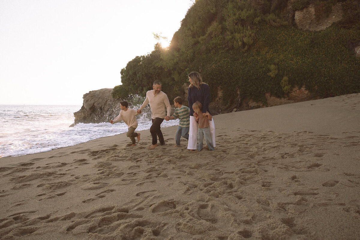 family of five walking at laguna beach with kids