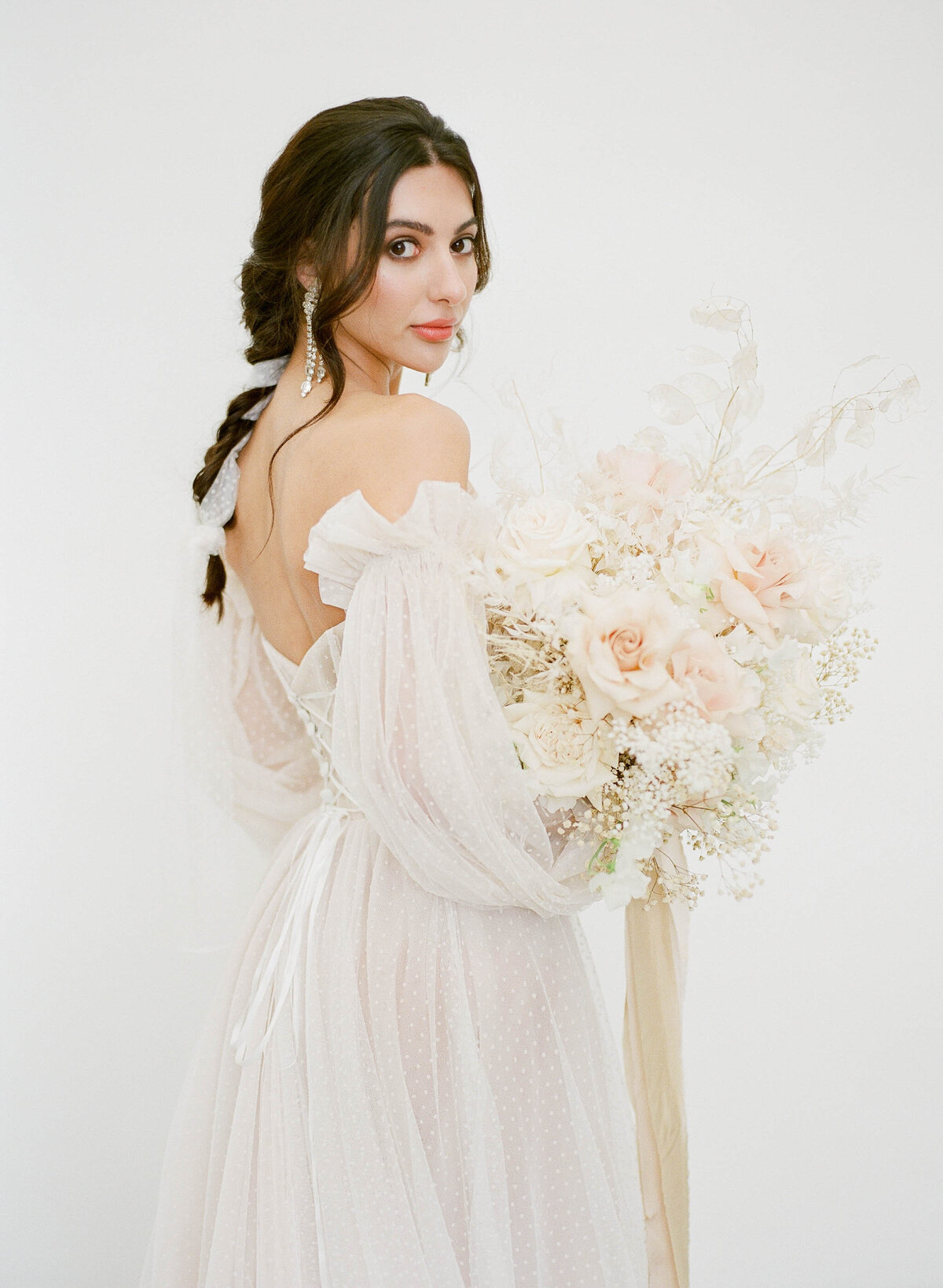 bride with braided hair and minimalist neutral bouquet
