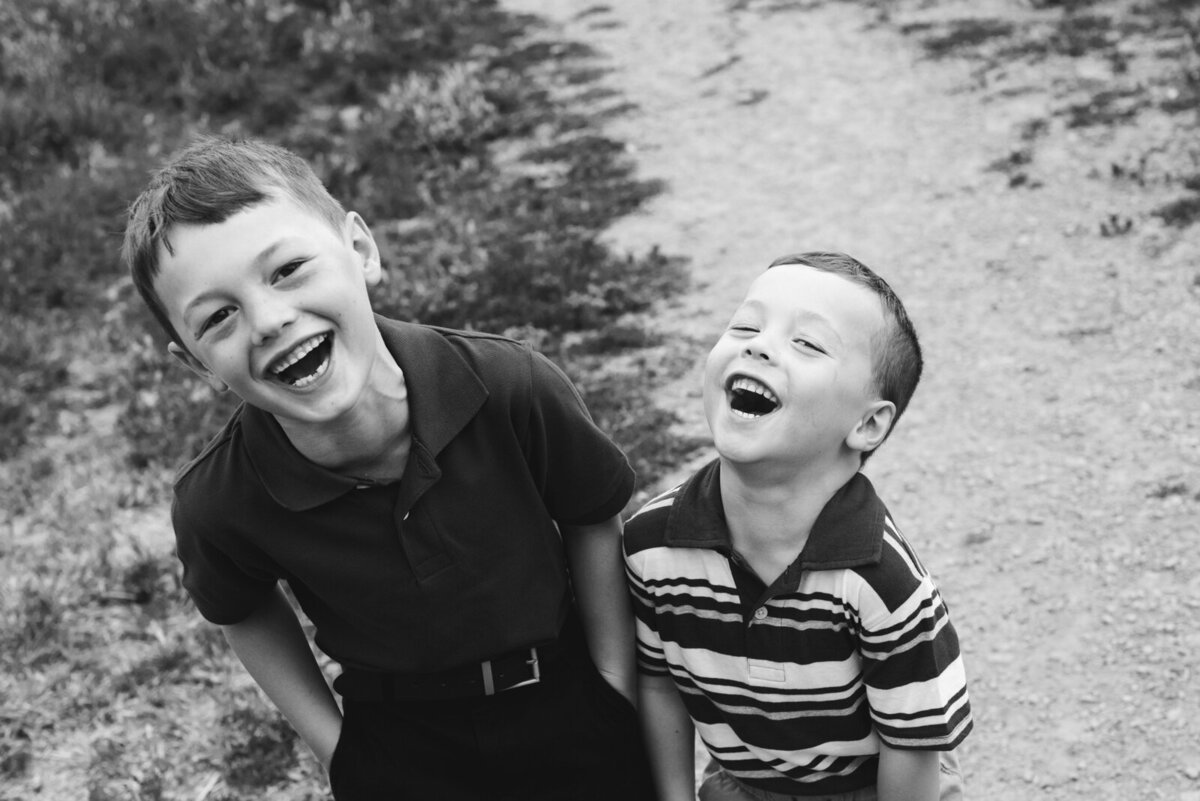 young brothers laughing at the camera in black and white