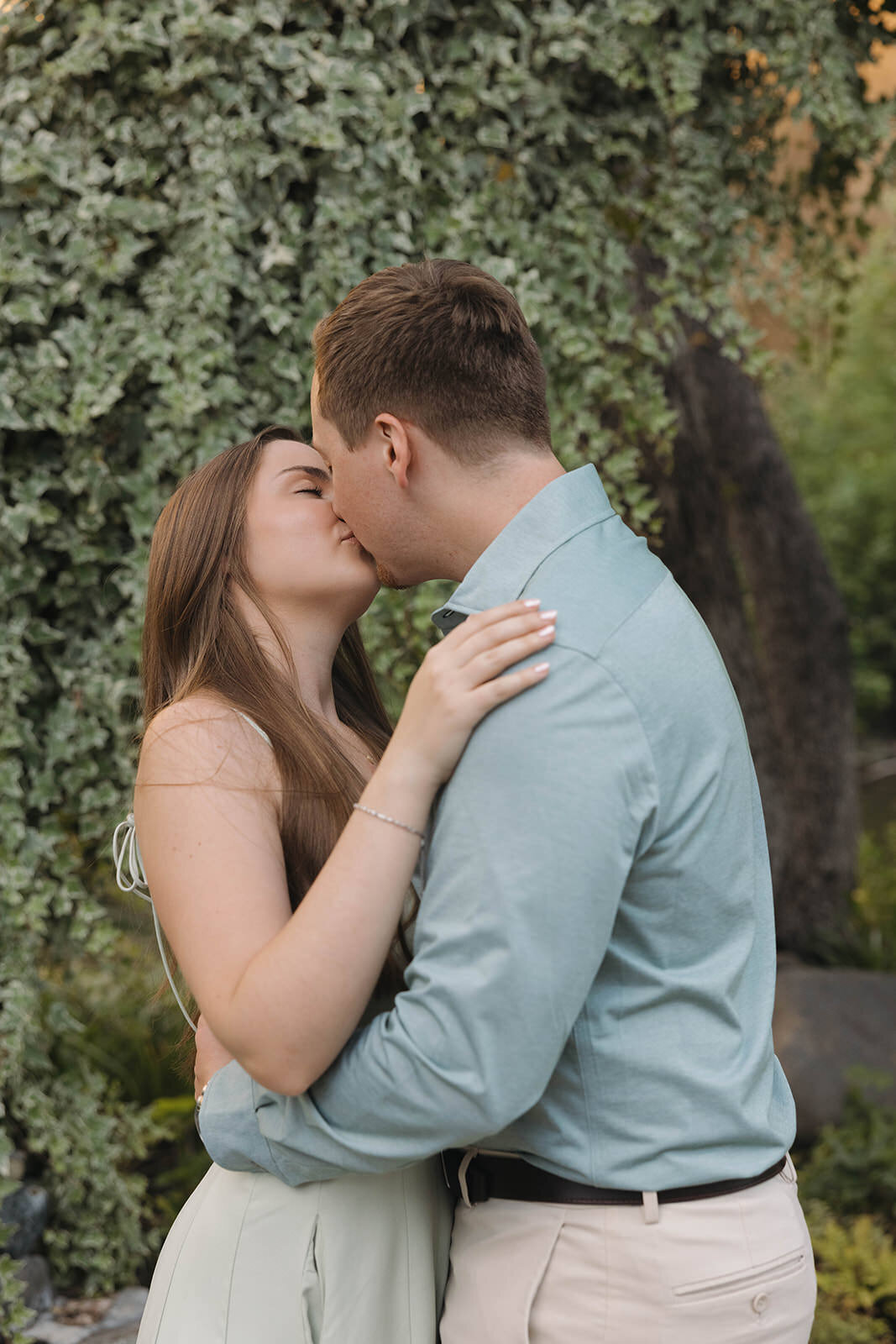 Engaged couple kissing in the garden