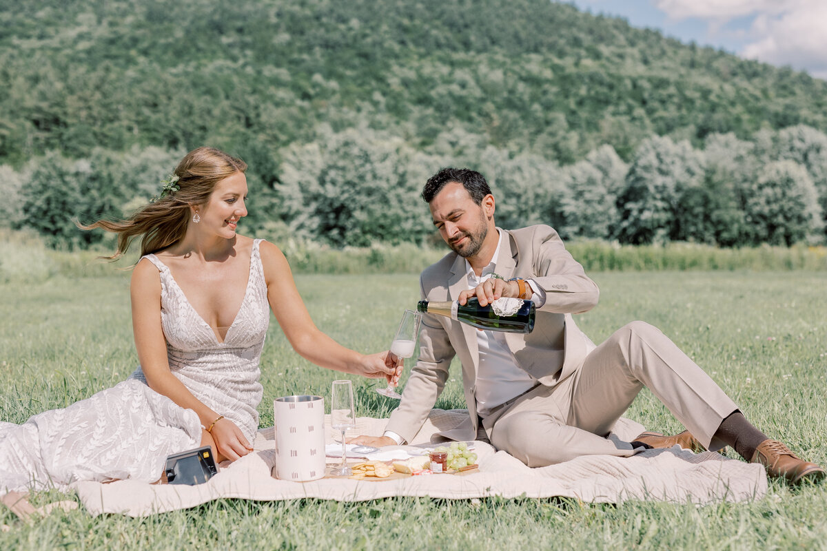 Bride and Groom sharing a picnic in a field in Keene Valley, NY.