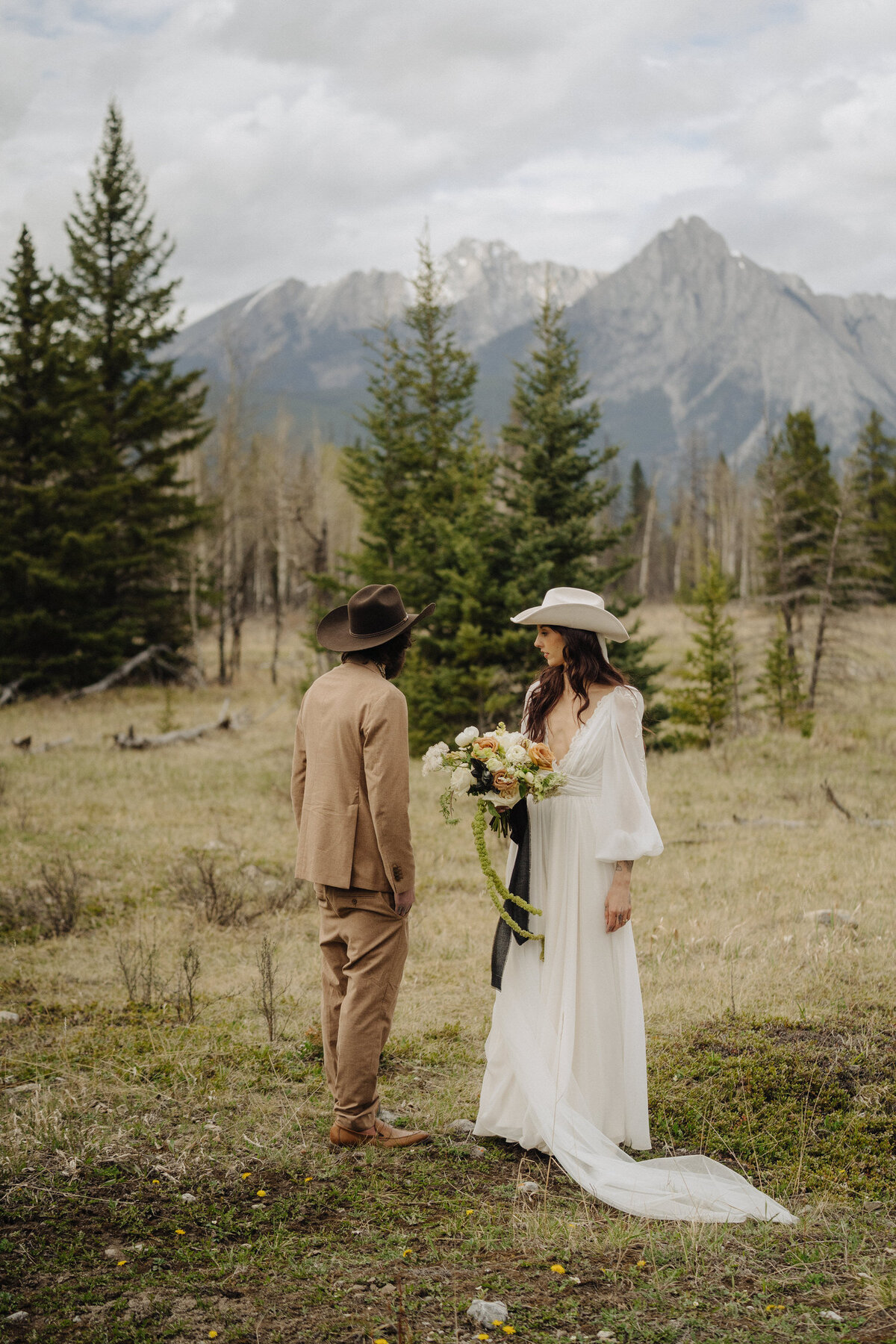 bride and groom walking across mountain scape