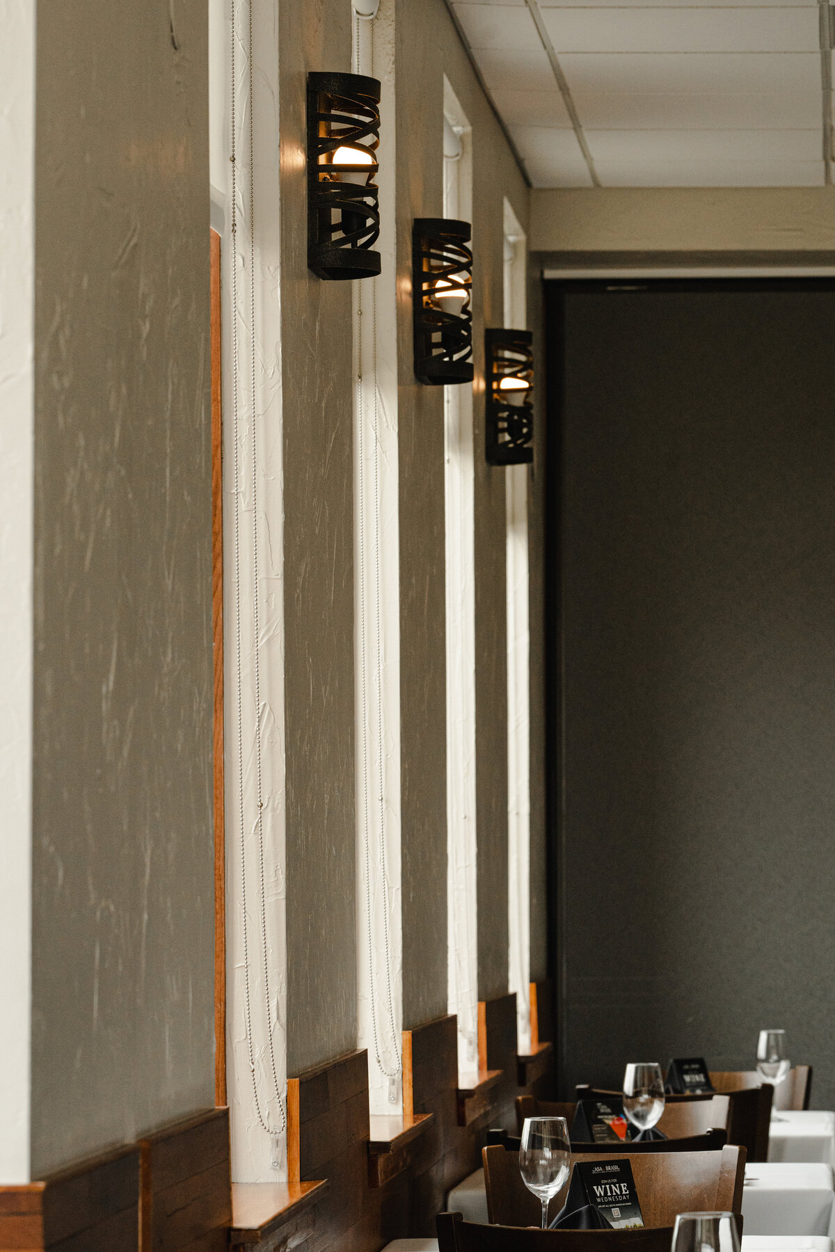 wall sconces between windows next to dining tables in restaurant