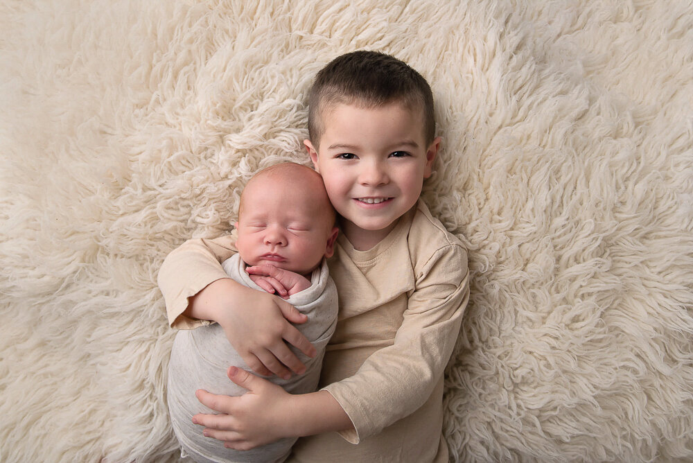 Big brother holding his newborn brother for their Hamilton photos.