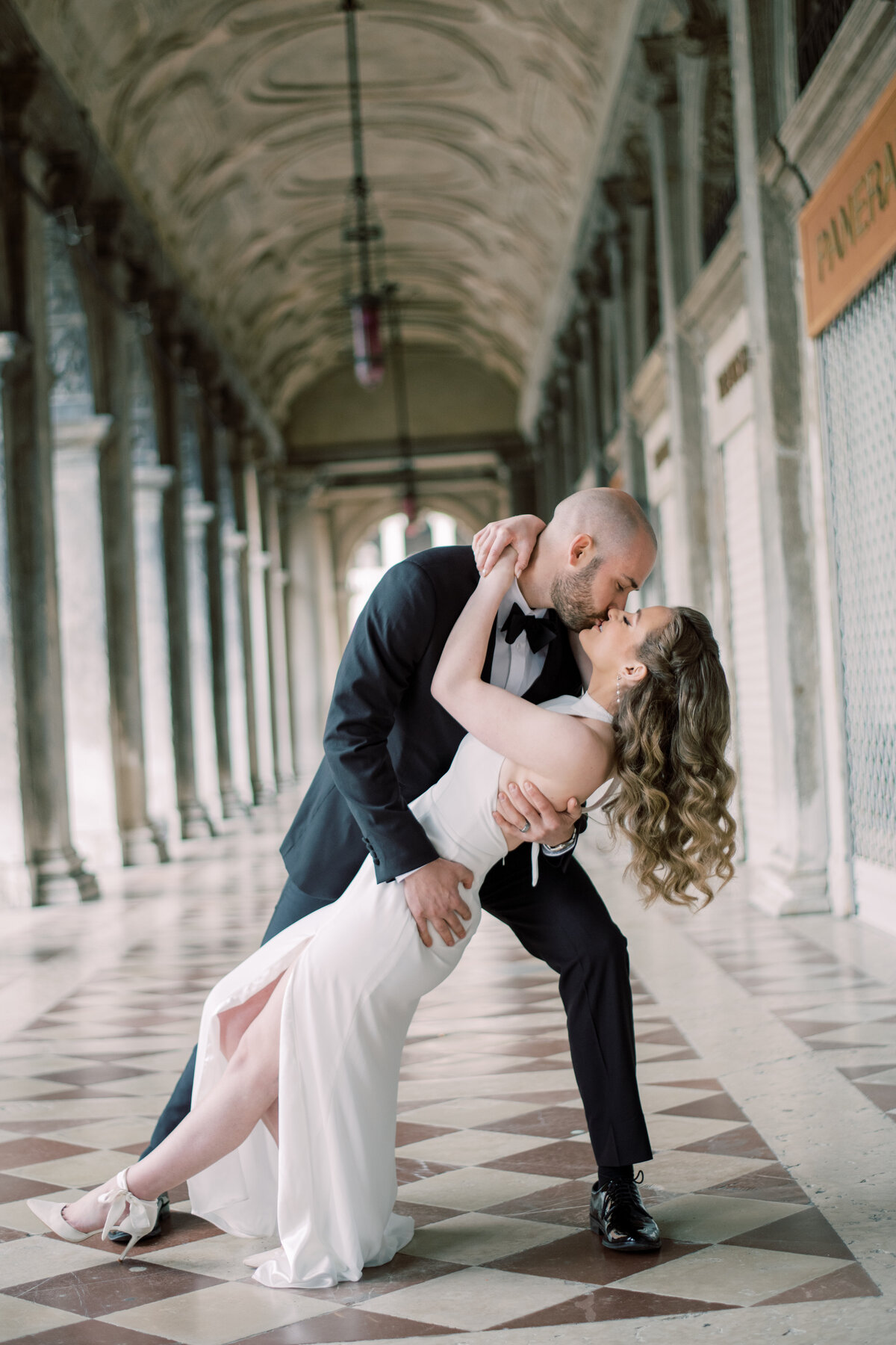 Engaged couple, in venice Italy, male dips woman down in the hallway