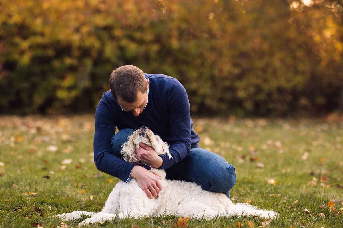 Dad snuggles with the puppy in the backyard Vermont Dog Photographer
