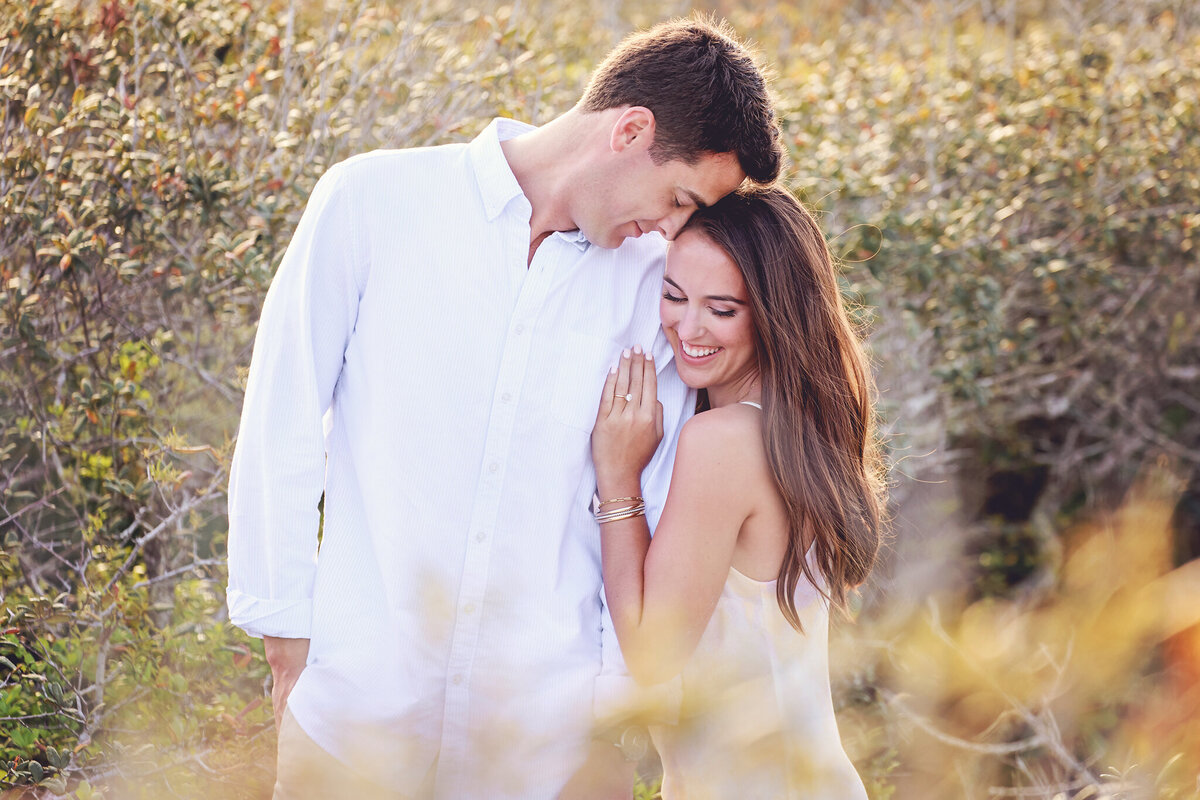 newly engaged couple on the trail at Grayton beach state park wearing neutrals and whites.