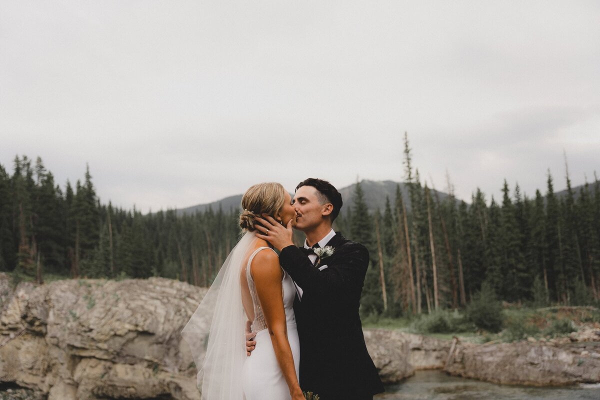 Wedding couple kissing at Elbow Falls, Alberta