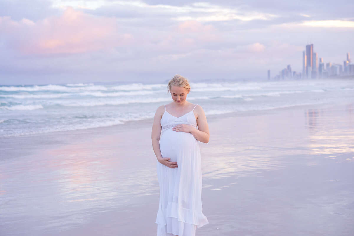 girl holding belly bump anticipating twin boys in gold coast maternity session