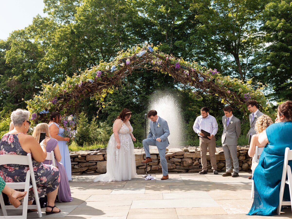 Groom steps on the glass to commemorate his marriage during a Jewish wedding ceremony.