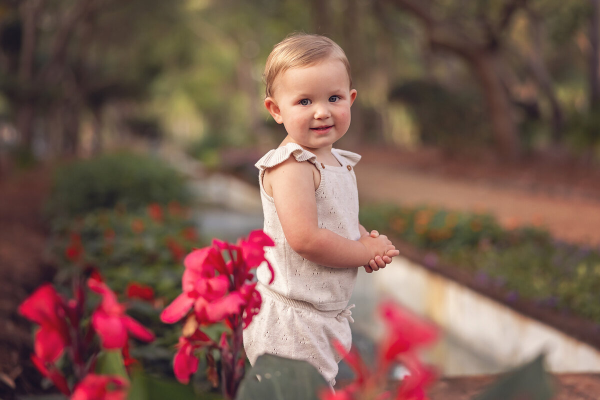 little girl standing by flowers near the water feature at cerulean park inside watercolor, florida.